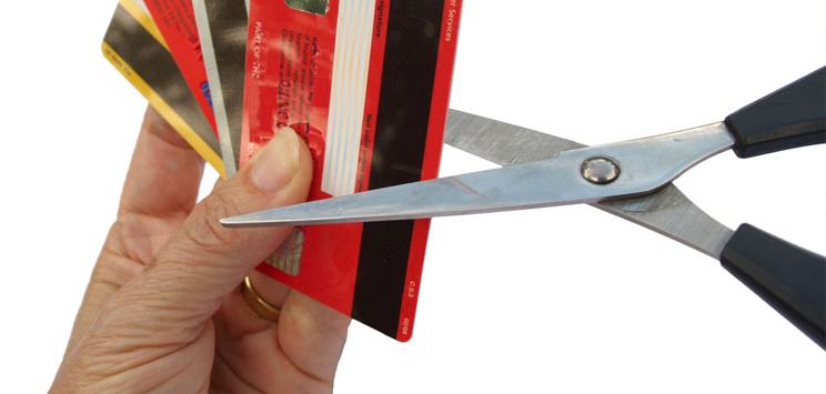 hand cutting up credit cards