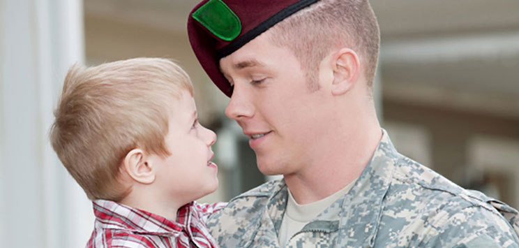 soldier holding toddler boy