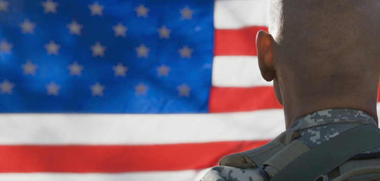 american soldier standing in front of the american flag