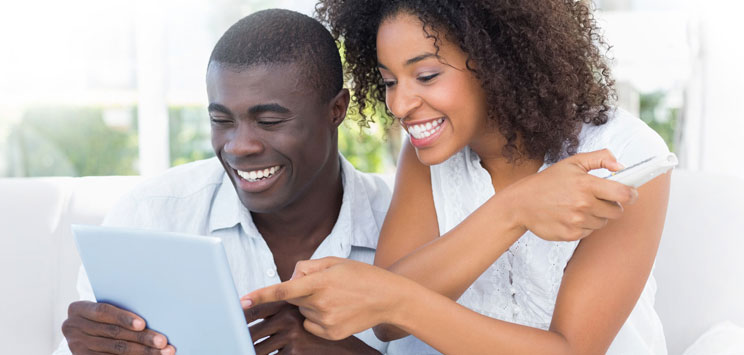 couple using tablet and smiling