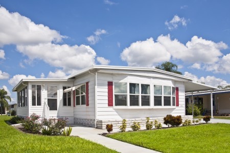 manufactured home with blue sky and green grass